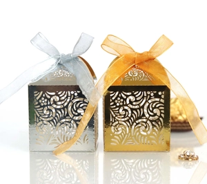 Detailed close-up of laser-cut wedding favor boxes with elegant organza ribbons