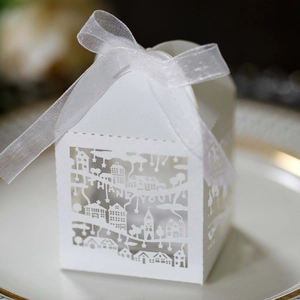 Detail of white house shaped candy box with laser cut THANK YOU text and ribbon
