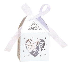 Detail of white laser-cut LOVE heart candy box with elegant ribbon and hollow pattern