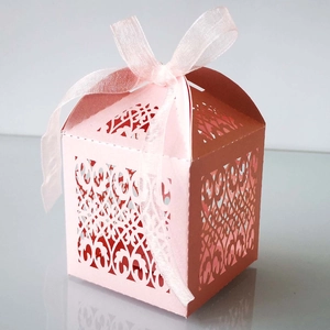 Detailed laser-cut vine patterns on a coral pink gift box with a silk ribbon bow