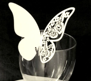 Détail d'un marque-place papillon blanc découpé au laser sur un verre pour mariage