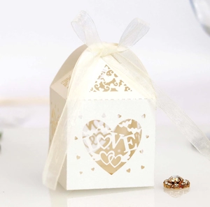Macro detail of laser-cut hollow heart candy box with LOVE text and white silk ribbon