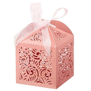 Detail of pink laser-cut gift box with wave scroll patterns and a sheer ribbon