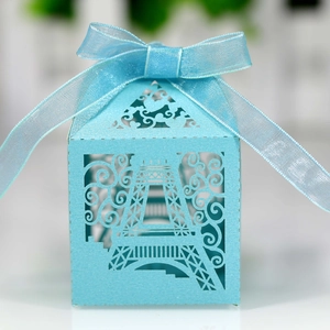 Detail of light blue laser-cut favor box with Eiffel Tower motif and satin ribbon