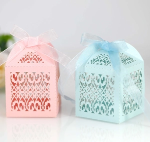 Detailed laser-cut wedding favors boxes in pink and blue with elegant ribbons