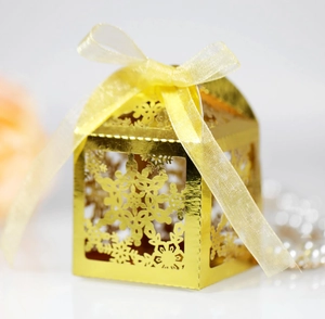 Detail shot of golden snowflake laser cut candy box with elegant yellow ribbon bow