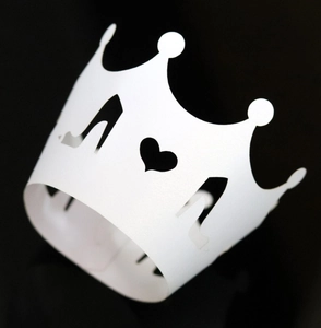 Laser cut cupcake wrapper detail featuring hollow heart and high heel patterns in white