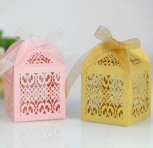 Detail of pink and gold laser-cut candy boxes with elegant organza ribbon bows