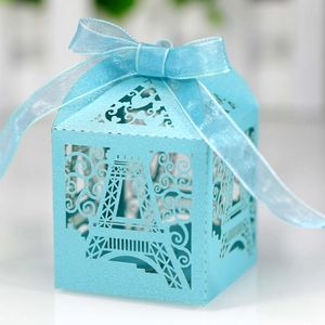 Macro detail of laser-cut Eiffel Tower candy box with light blue shimmer and organza ribbon
