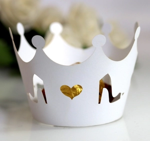Detail of laser-cut cupcake wrapper with crown edge, high heel and heart hollow design