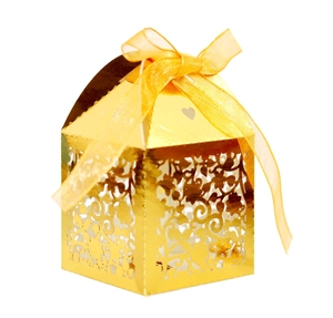 Elegant gold laser-cut favor box with floral patterns and a matching satin ribbon bow