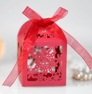 Detail of red hollowed-out snowflake gift box with translucent organza ribbon bow