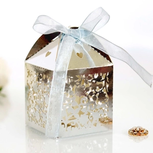 Macro view of silver laser-cut wedding candy box with floral patterns and blue ribbon
