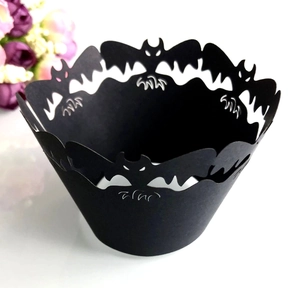 Macro detail of laser-cut black lace cupcake wrappers with Halloween bat patterns