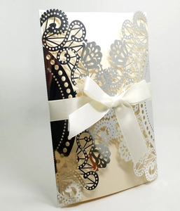 Elegant laser cut silver wedding invitation with cream inner page and white ribbon bow