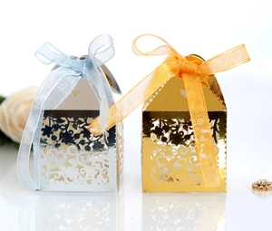 Detail of laser-cut hollow gift boxes in gold and silver with elegant ribbon bows
