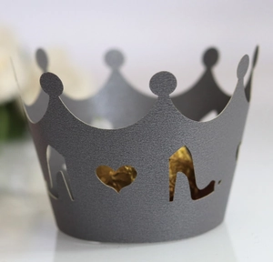 Detail of silver crown cupcake wrapper with laser-cut heart patterns and golden contents