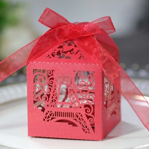 Detailed laser-cut Eiffel Tower favor box in vibrant red with a matching ribbon tie