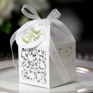 Laser cut white wedding favor box with ribbon and gold Thank You gift tag on plate