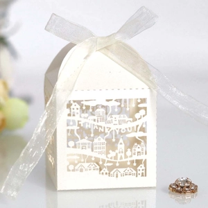 Detail of white house-shaped laser cut favor box with THANK YOU text and organza ribbon