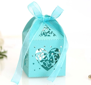 Macro detail of laser-cut heart and LOVE pattern on teal wedding gift box with ribbon
