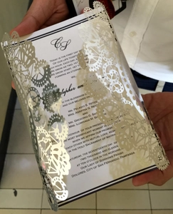 Laser-cut floral wedding invitation set with shimmering silver and gold hollow design