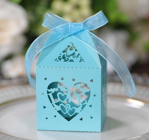 Macro detail of laser-cut light blue favor box featuring LOVE heart and ribbon