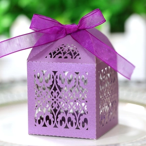 Detailed laser-cut hollow pattern on purple favor box with elegant silk ribbon bow