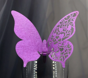 Purple glitter butterfly place card with intricate laser-cut heart patterns for wine glasses