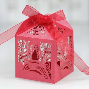 Macro detail of red Eiffel Tower laser-cut candy box with organza ribbon bow