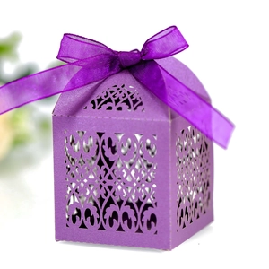 Detail of purple laser-cut wedding favor box with an elegant ribbon bow on top