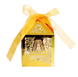 Detail of laser-cut Eiffel Tower candy box in shiny gold with a yellow ribbon bow