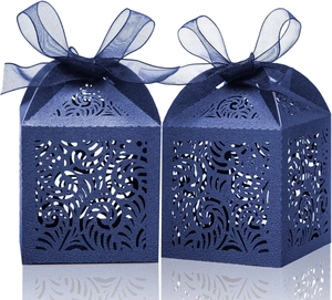 Detail of laser-cut European pattern on navy blue wedding favor box with organza bow