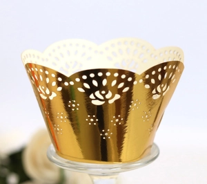 Detailed macro shot of laser-cut golden rose lace pattern on cupcake paper wrappers