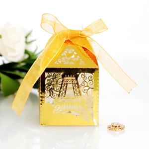 Detailed laser-cut Eiffel Tower favor box in gold with yellow organza ribbon