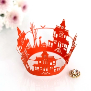 Detail of laser-cut orange cupcake wrapper with Halloween castle and pumpkin motifs