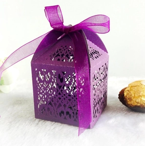 Detail of laser-cut hollow pattern and purple ribbon on an elegant gift candy box