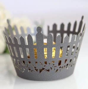 Detail of silver laser-cut cupcake wrapper with a fence pattern for wedding decorations