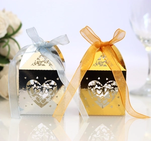Detail of mirror gold and silver laser-cut LOVE candy boxes with organza ribbon bows