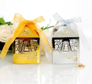 Detail of laser-cut Eiffel Tower favor boxes in gold and silver with elegant ribbons