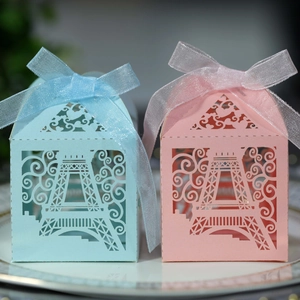 Detail of laser-cut Eiffel Tower favor boxes in light blue and pink with ribbons