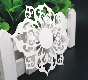 Intricate white laser-cut snowflake paper art coaster for wedding and Christmas decor