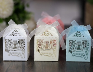 Detailed laser-cut Eiffel Tower favor boxes with elegant ribbons for wedding and party gifts