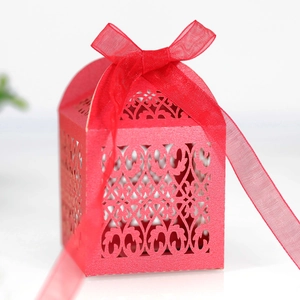 Detailed laser-cut hollow pattern on a red wedding favor box with organza ribbon bow