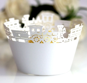 Detailed close-up of white laser-cut cupcake wrapper featuring hollow train and star pattern