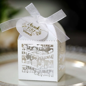 Macro shot of white laser-cut THANK YOU gift box with ribbon and tag details