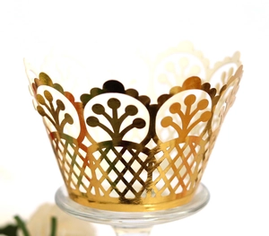 Laser-cut hollow golden cupcake wrappers with intricate floral patterns for party decor