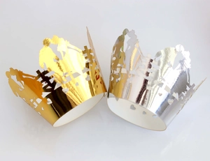Elegant laser cut wedding cupcake wrappers in shiny gold and silver with romantic silhouettes