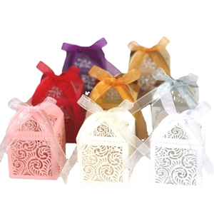 Laser-cut floral wedding favor boxes in multiple colors with matching satin ribbons