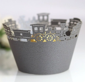 Intricate laser-cut train design on silver cupcake wrappers for party decorations